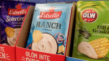 İsveç marketinde patates cipsi sosu yapmak için pudra torbaları. Karışık, baharatlı.