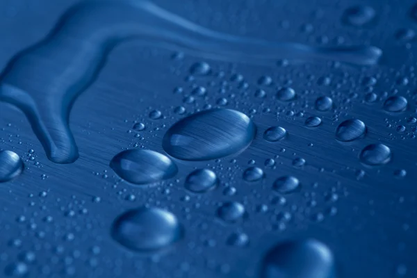 푸른 배경에 물방울이 떨어진다 — 스톡 사진