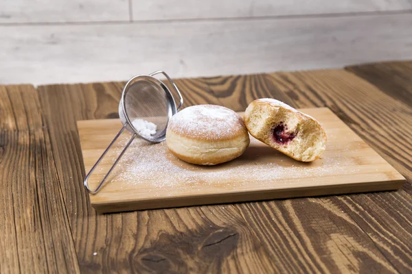 Свежие пончики на деревянном столе — стоковое фото