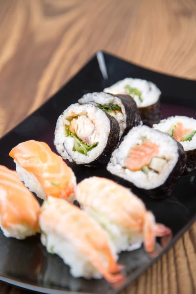 Fresh Japanese tasty sushi roll set with chopsticks on table — Stock Photo, Image