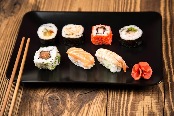 Fresh Japanese tasty sushi roll set with chopsticks on table — Stock Photo, Image