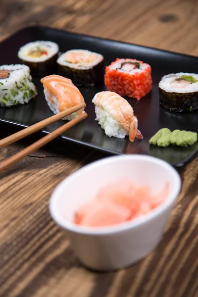 Fresh Japanese tasty sushi roll set with chopsticks on table — Stock Photo, Image