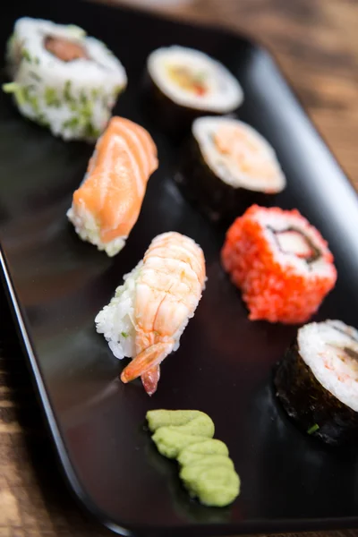 Fresh Japanese tasty sushi roll set with chopsticks on table — Stock Photo, Image