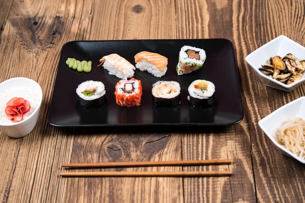 Fresh Japanese tasty sushi roll set with chopsticks on table — Stock Photo, Image