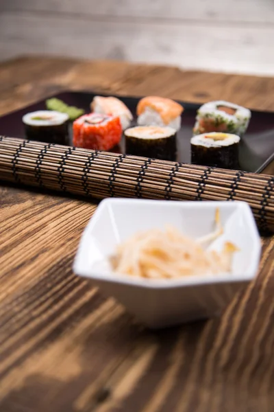Fresh Japanese tasty sushi roll set with chopsticks on table — Stock Photo, Image