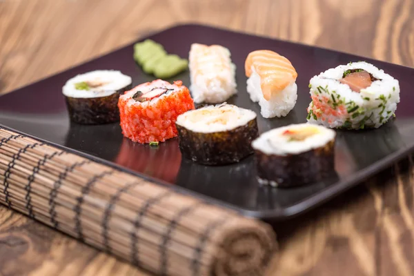 Fresh Japanese tasty sushi roll set with chopsticks on wooden ta — Stock Photo, Image