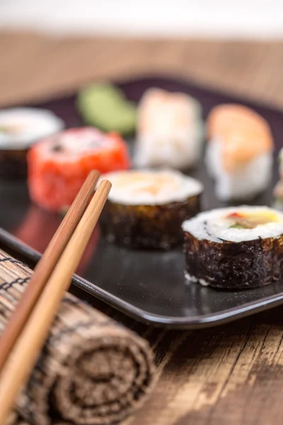 Fresh Japanese tasty sushi roll set with chopsticks on wooden ta — Stock Photo, Image