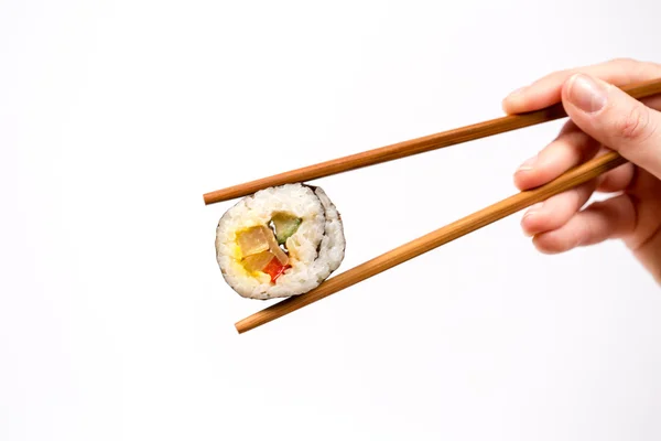 Hand holding Sushi roll with bamboo chopsticks isolated on white — Stock Photo, Image