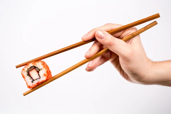 Rotolo di sushi con bacchette di bambù isolato su bianco — Foto Stock