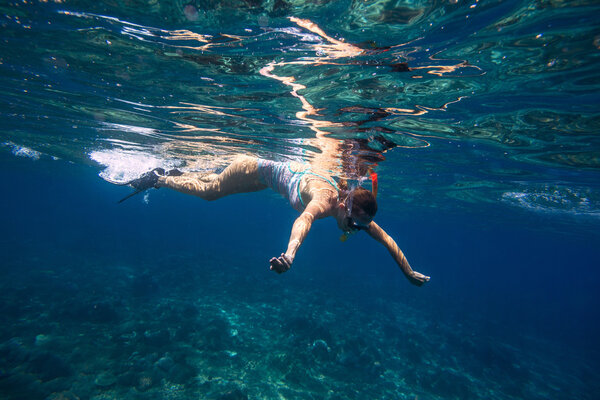 Молодые женщины ныряют с маской в тропической воде
