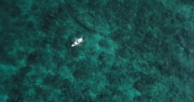 Laquedivas Denizi, Maldivler 'in turkuaz sularındaki bir sörfçünün hava görüntüsü