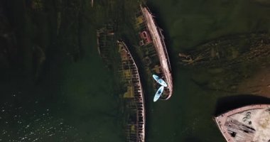 Barents Denizi 'ndeki gemi enkazlarının yanında birkaç sup sörfçüsü.