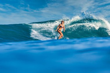 Mavi dalgada dişi sörfçü