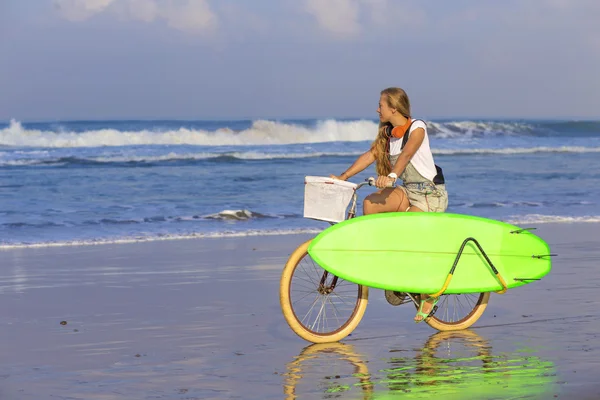 Surfer girl with a bicycle — Stock Photo, Image