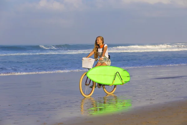 Surfer girl with a bicycle — Stock Photo, Image