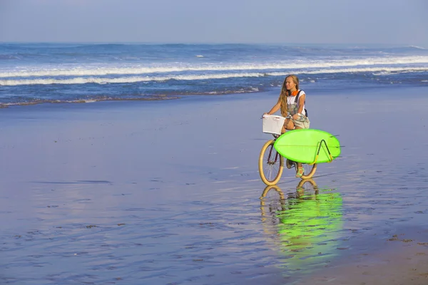 Surfer girl with a bicycle — Stock Photo, Image