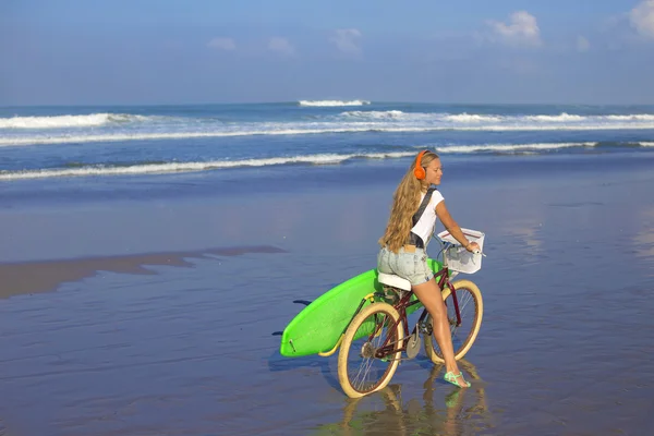Surfer girl with a bicycle — Stock Photo, Image