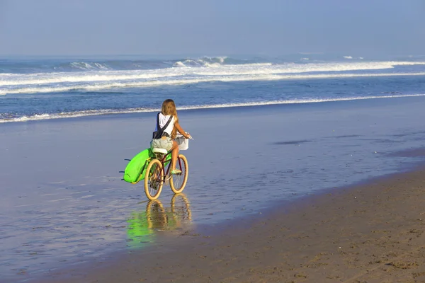 Surfer girl with a bicycle — Stock Photo, Image