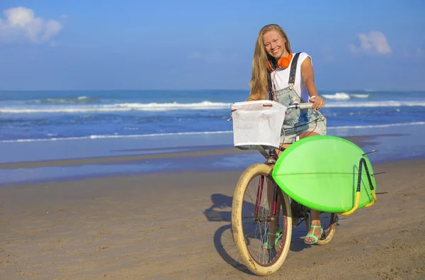 Surfer girl with a bicycle — Stock Photo, Image