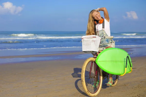 Surfer girl with a bicycle — Stock Photo, Image