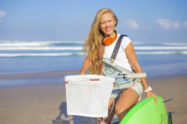 Surfer girl with a bicycle — Stock Photo, Image