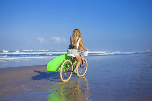 Surfer girl with a bicycle — Stock Photo, Image