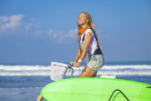 Surfista chica con una bicicleta —  Fotos de Stock