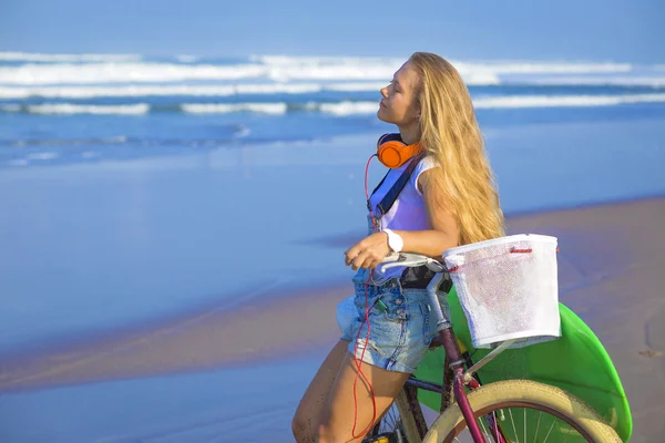 Surfer girl with a bicycle — Stock Photo, Image