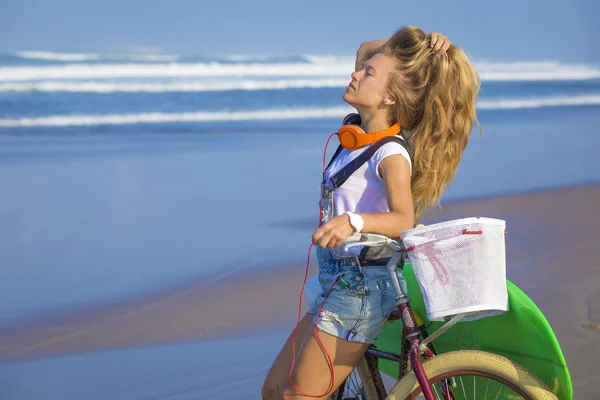 Surfer girl with a bicycle — Stock Photo, Image