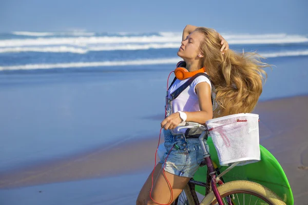 Surfer girl with a bicycle — Stock Photo, Image