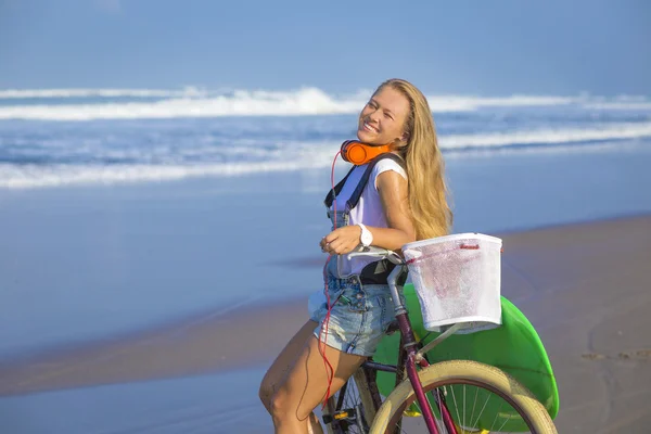 Surfer girl with a bicycle — Stock Photo, Image