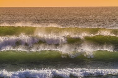 gündoğumu ve parlayan dalgalar okyanusta