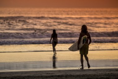 Sörfçü günbatımı zaman sahilde