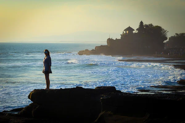 Jovem mulher no oceano cpastline com templo hindu Pura Tanah Lot — Fotografia de Stock