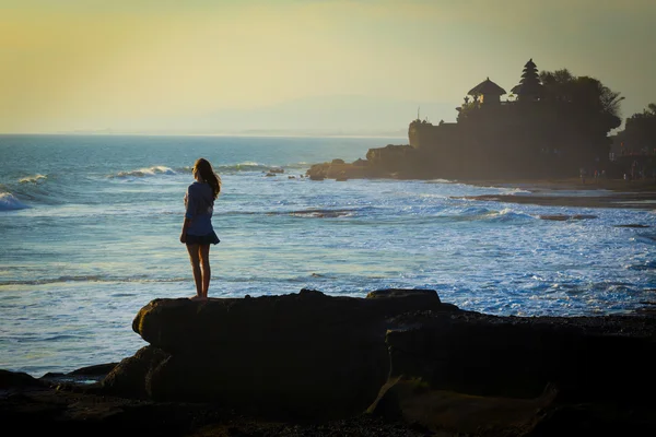 Jovem mulher no oceano cpastline com templo hindu Pura Tanah Lot — Fotografia de Stock