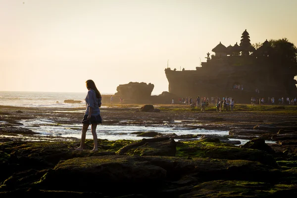 Ung kvinna på ocean cpastline med hinduiska templet Pura Tanah Lot — Stockfoto