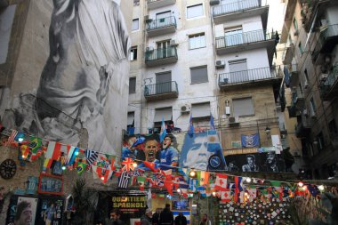 Napoli, İtalya - Şubat 06: 2021: Napoli taraftarları tarafından Maradona 'nın Pibe de Oro.imajı ve en ünlü futbolculara ithaf edilen alana İspanyol Mahallesi, pankartlar ve renkli bayraklar konuldu.