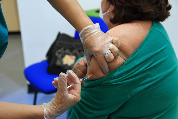 Naples, Italy - January 09,2021 : The Local Health Company 1 Naples Center , has established a Vaccination Center against Covid-19 . Indoor salt of the center anti-ovidium-19 vaccine.A nurse vaccinates an elderly person.