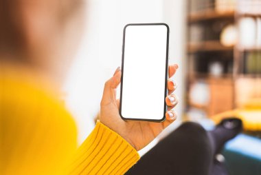 Evin içinde akıllı telefon çerçevesiz boş ekran kullanan bir kadın. Ev kavramından çalışmak - video çağrısı