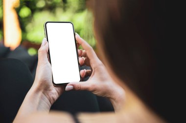 Kız bahçede kanepede yatarken akıllı telefon boş ekran çerçevesiz modern tasarım kullanıyor.