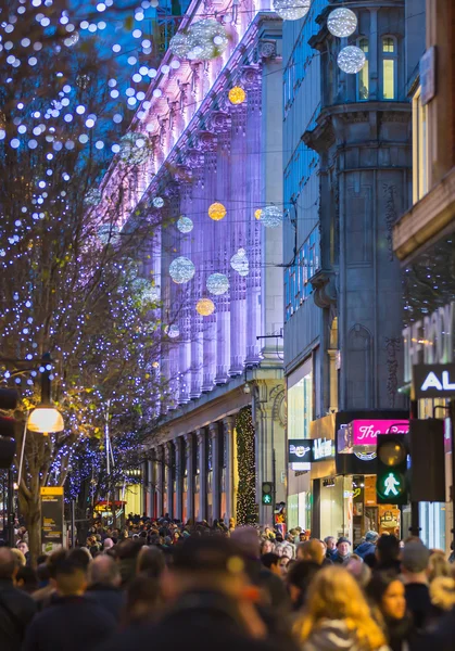 Utsmykning av julelys på Oxford Street og mange som går på julesalget i London – stockfoto