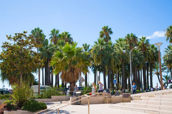 CANNES, FRANCIA - 19 DE SEPTIEMBRE DE 2016: Palmeras de Cannes, pequeño parque junto a la playa con gente paseando — Foto de Stock