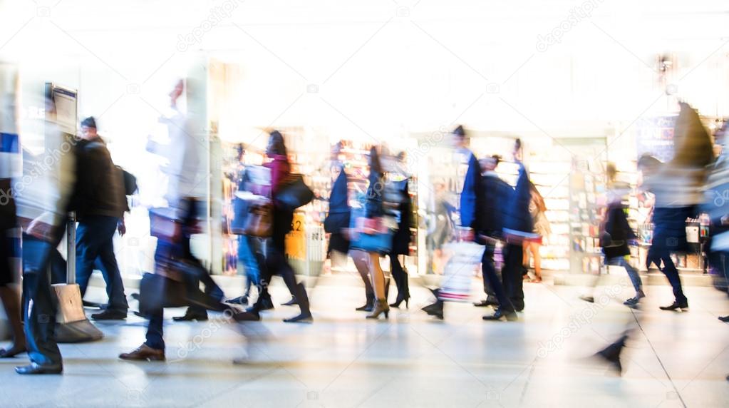 Blur of office workers walking pass the Canary Wharf tube station in early morning rush hours