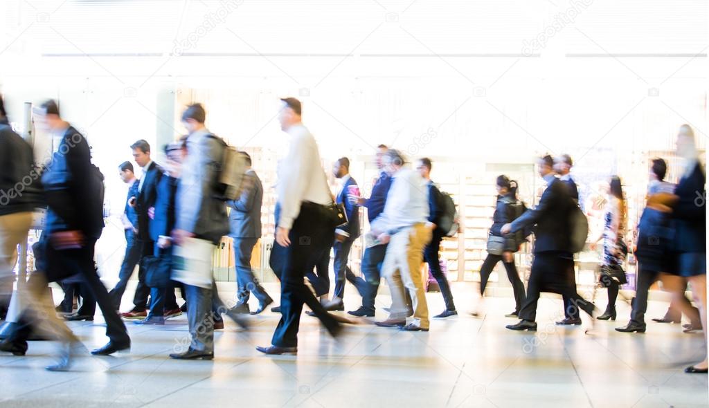 Blur of office workers walking pass the Canary Wharf tube station in early morning rush hours