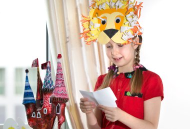 Küçük kız onun resim sanatı gösteren çalışır, kağıt masher peri castle. Onun sanat zanaat çalışmaları, kağıt masher peri kale ve aslan kağıt maske gösteren küçük kız.