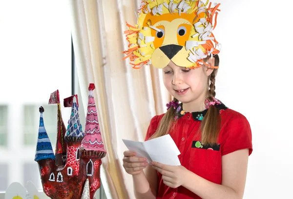 Niña demostrando sus obras de arte artesanal, papel masher castillo de hadas. Niña demostrando sus obras de arte artesanal, papel masher castillo de hadas y máscara de papel León . — Foto de Stock