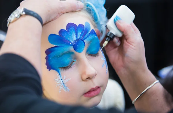 Pittura facciale natalizia, Ritratto di bambina durante la sessione di pittura facciale — Foto Stock