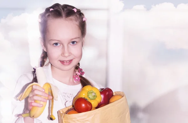 小さなかわいい女の子を保持する野菜や果物の袋 — ストック写真