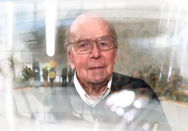 Портрет 95-летнего англичанина, сидящего в кресле в домашней обстановке со стеклянным эффектом. Концепция здравоохранения и ухода — стоковое фото
