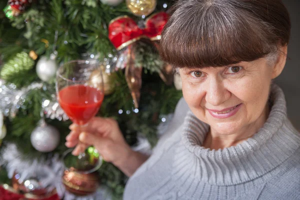 Mulher de boa aparência em idade madura contra a árvore de Natal. Fundo de Natal — Fotografia de Stock